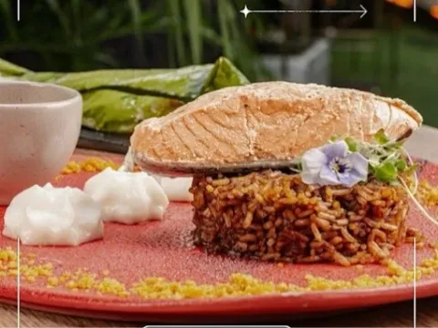 Plato de arroz acompañado de un filete de pescado, vegetales y salsas, presentado de forma creativa.