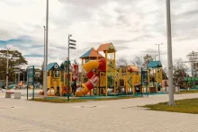 A children's playground with a colorful slide and a set of play equipment.