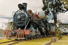 An old train on the tracks, covered in colorful graffiti and weathered by time.