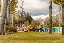 A park with a playground and leafy trees, ideal for enjoying the outdoors.