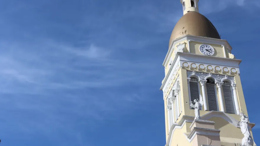 Iglesia Parroquial Inmaculada concepción - Cajicá su torre del reloj blanca con cielo azul.