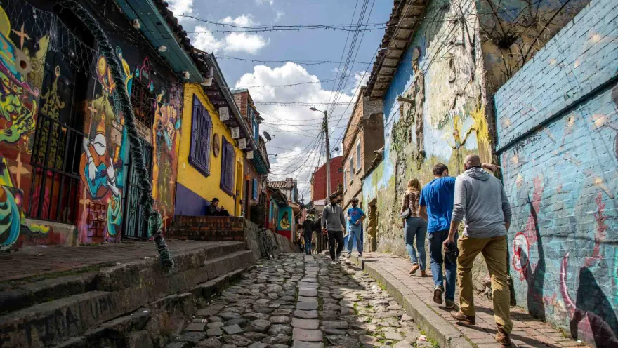 La Candelaria – Callejón del Embudo, a narrow cobblestone street with brightly painted houses and people walking.