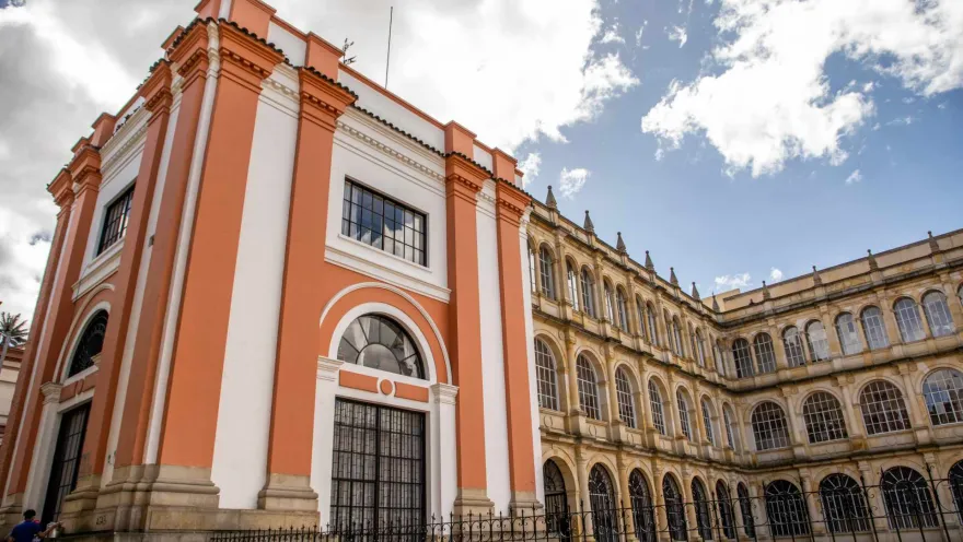 Iglesia San Ignacio desde el costado del colegio San Bartolomé con cielo azul y alguna nubes.