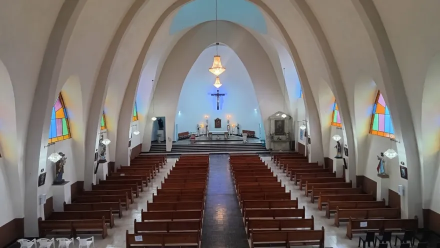 Santurio San Ignacio de Loyola - Supatá interior vacía se observan ovalos en el techo y las sillas completamente vacías. Al fondo de llogra ver la cruz y un par de lámparas.