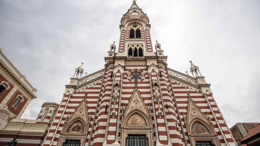 Santuario Nuestra Señora del Carmen primer plano vista desde abajo desde las tres puertas a la punta de la torre gótica. El cielo está gris.