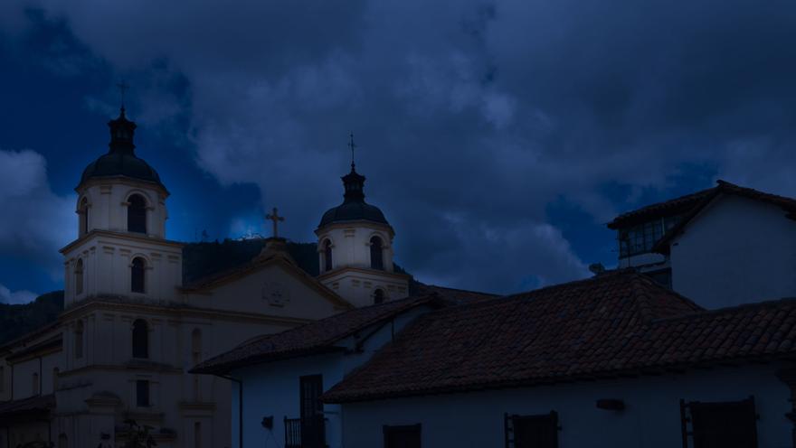 Techo de la iglesia de La Candelaria en tono azul como de anochecer. Se observa el techo en teja de barro de una casa vecina.