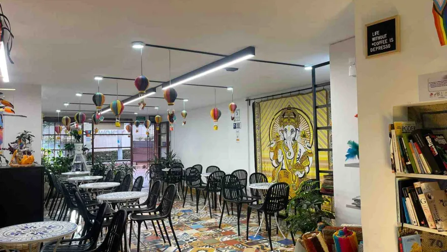 The interior of an Arabic-style restaurant with several round tables and chairs arranged around them. Balloon-shaped decorations with baskets hang from the ceiling
