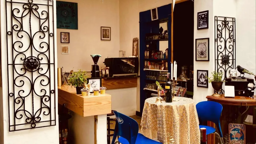 Salón de té o de café con decoraciones antiguas. Y al fondo sobre una barra de madera dos máquinas para hacer café.