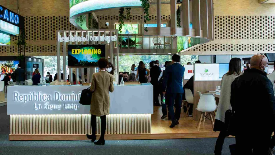 An event hall with a large booth that reads "Dominican Republic." People are gathered around.