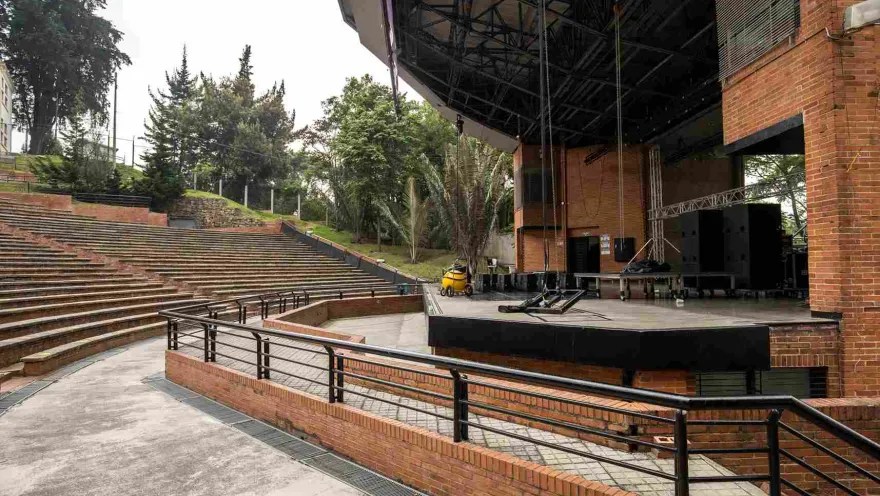 Close-up of the stage with some sound speakers. Trees surround the area.