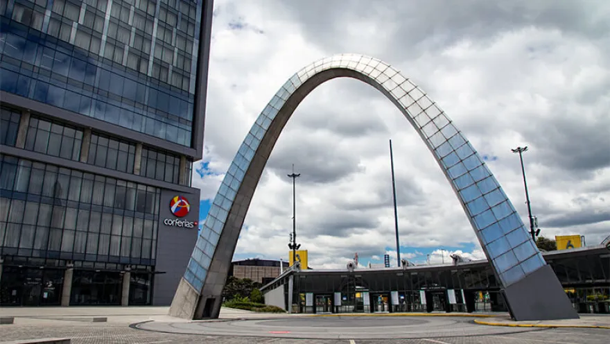 The main entrance of Corferias with its giant oval made of metal and concrete. Next to it is a tall building with the Corferias logo.