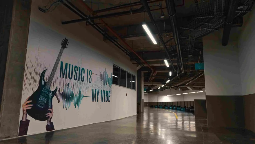 Inside, a white wall with a poster in blue lettering that reads "Music is my vibe."