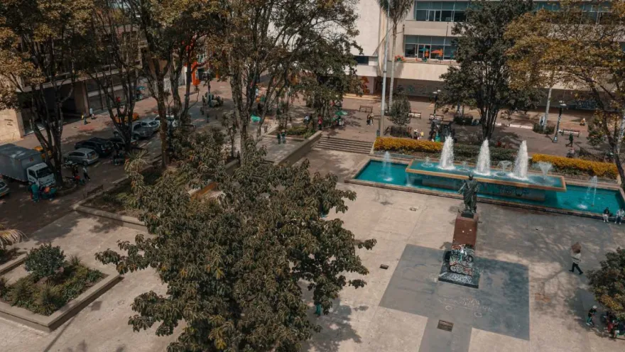 El Parque Santander vista desde arriba, se observan  3 fuentes de agua, la estatua de Bolívar y varios árboles altos. 