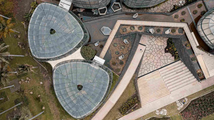Two glass structures seen from above. Next to them is a small plaza with stairs.