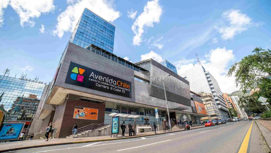 Fachada del Centro Comercial Avenida Chile, en baldosa gris y vidrio. Al frente hay una avenida sin carros. Hay detrás unos edificios altos en vidrio.