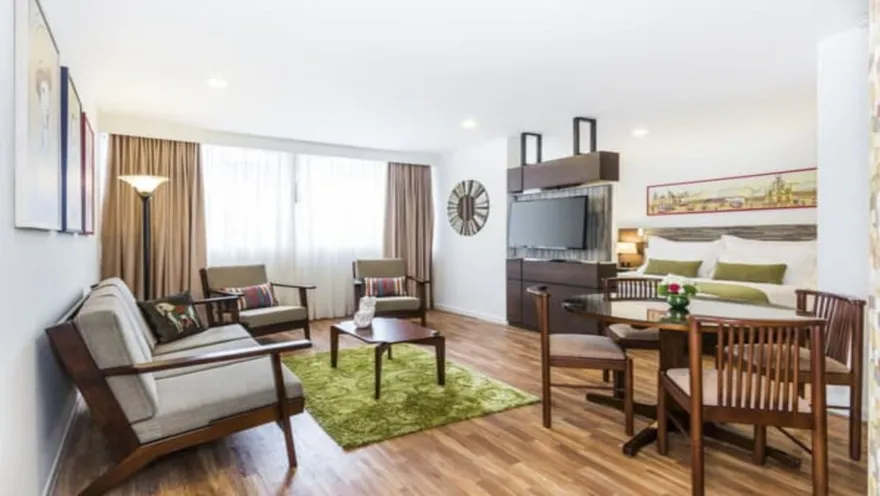 Una suite con acceso directo a un patio exterior amueblado, ofreciendo un espacio interior y exterior para relajarse. La habitación cuenta con una cama y una sala de estar.