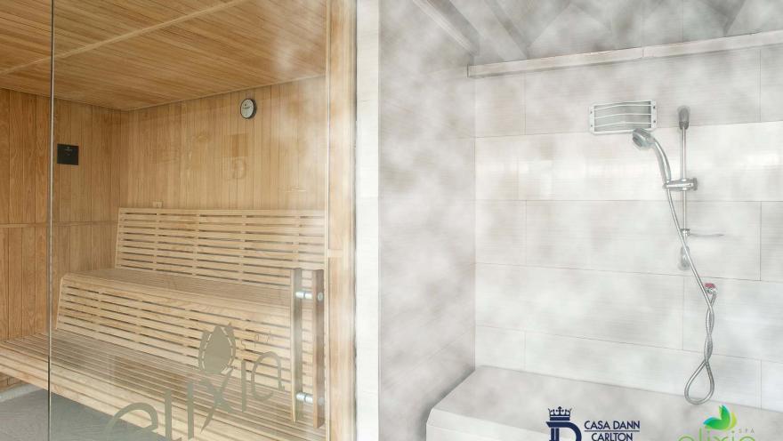 Salón tipo sauna y baño turco dividido por una pared de vidrio. Se observa una capa gruesa de vapor en el lugar.