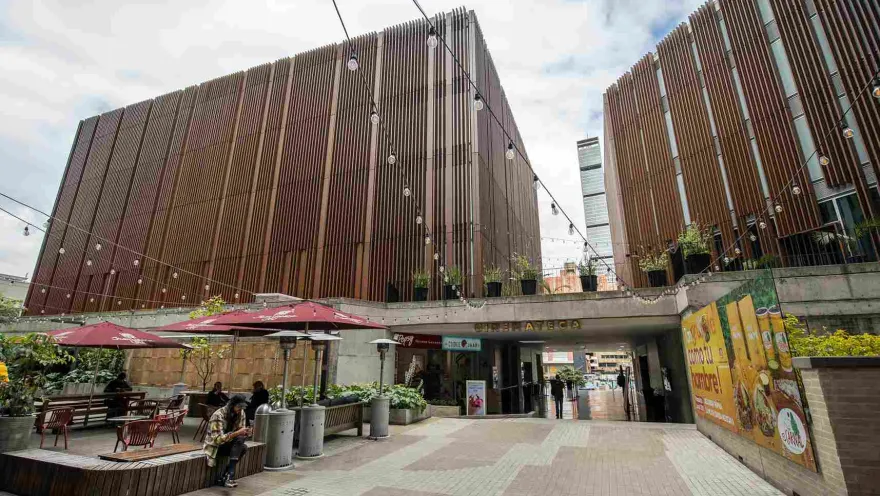 A large structure, a combination of wood and concrete, with a main entrance featuring a prominent bronze sign that reads ""Cinemateca"" (Cinematheque).