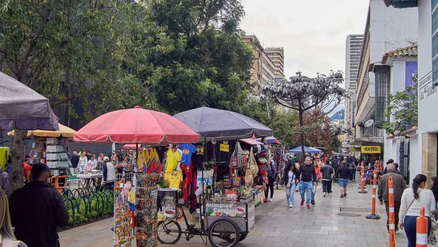 Panoramic view of a street with street vendors and people walking around.