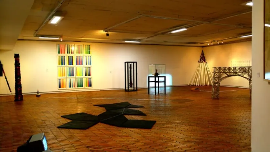 Interior room with picturesque works of art displayed on the walls and floor.