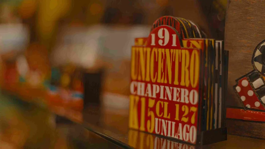 Carteles de transporte de servicio público con letras de color blanco y amarillo en fondo rojo. Se destaca una leyenda que dice: "Unicentro". 