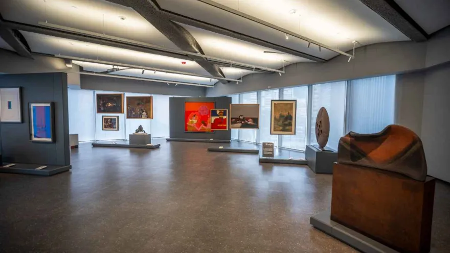 An art gallery with various works displayed on the walls and pedestals.