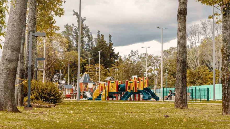 A park with a playground and leafy trees, ideal for enjoying the outdoors.