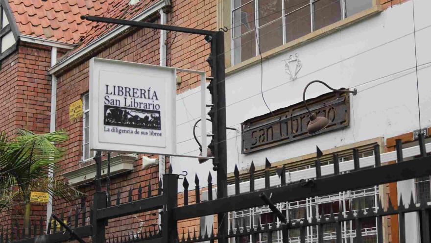 Facade of the San Librario bookstore with a hanging sign on a brick street.