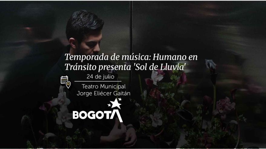 Un hombre mirando hacia abajo rodeado de flores moradas para el evento "Humano en Tránsito presenta 'Sol de Lluvia'".