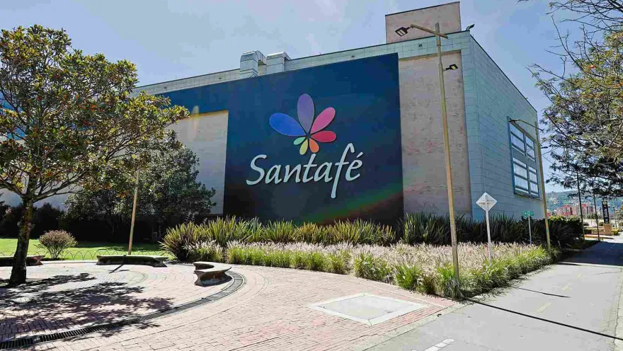 La fachada de Centro Comercial Santafé se integra con amplias zonas verdes y espacios peatonales, creando una bienvenida agradable y moderna. Su emblemático nombre y colorido logo se destacan como parte del paisaje urbano del norte de Bogotá.