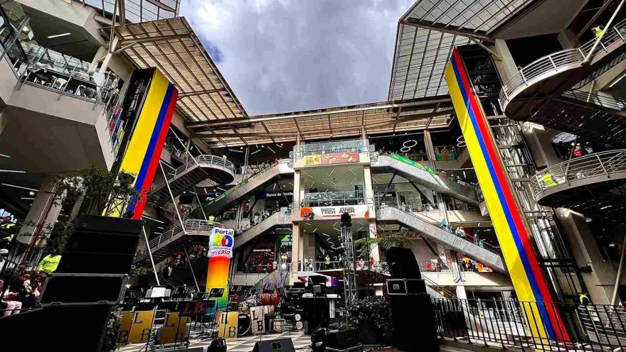 El amplio espacio central de Portal 80 combina arquitectura, comercio y entretenimiento en un ambiente dinámico. Sus escaleras, pasillos y grandes estructuras decoradas con los colores de Colombia crean un escenario ideal para eventos y actividades especiales.