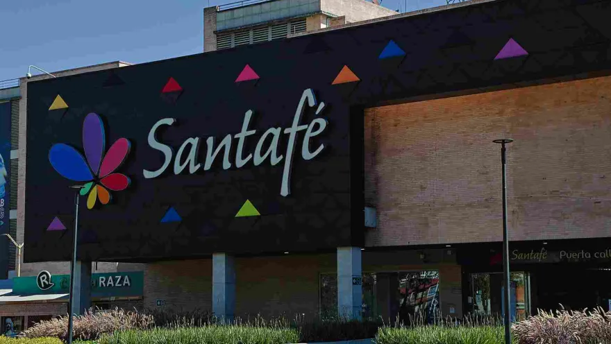 El colorido logo de Centro Comercial Santafé destaca sobre su moderna fachada, rodeada de amplias zonas verdes y espacios abiertos. Una imagen que refleja el carácter contemporáneo y acogedor de este importante punto de encuentro del norte de Bogotá.