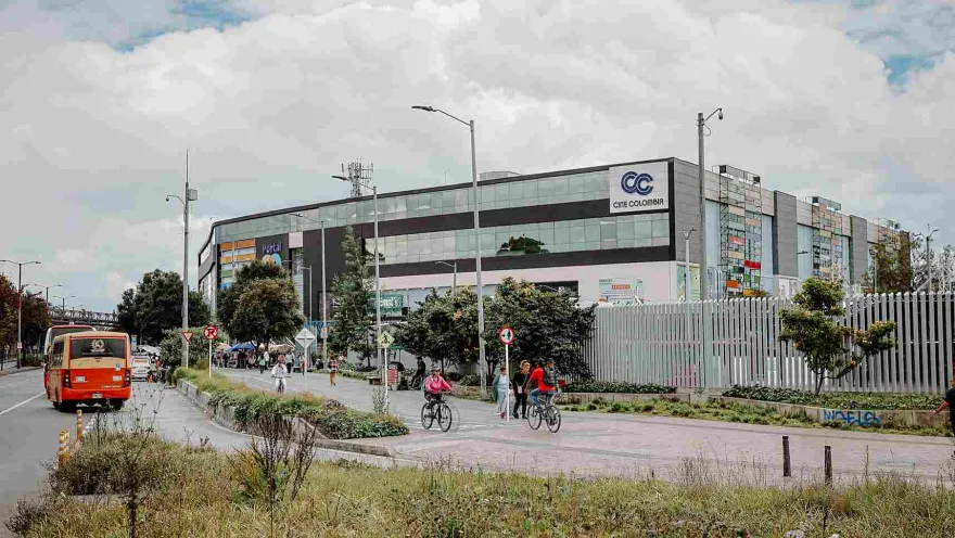 Una vista exterior de Portal 80 muestra su ubicación estratégica y su conexión con la movilidad del sector. Rodeado de amplios espacios peatonales y ciclorrutas, el centro comercial se integra al dinámico paisaje urbano del occidente de Bogotá.