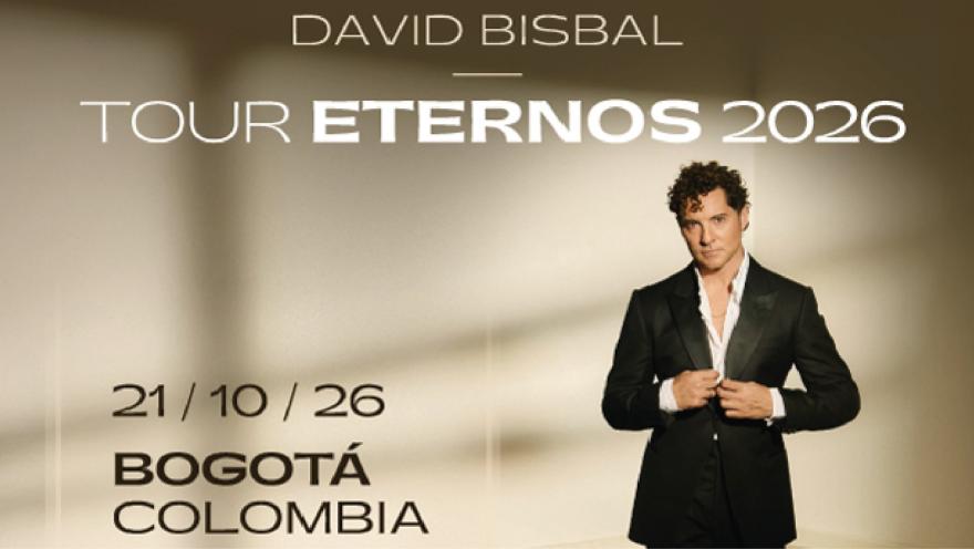 David Bisbal con cabello rizado y traje elegante, mirando de frente mientras se ajusta la chaqueta.
