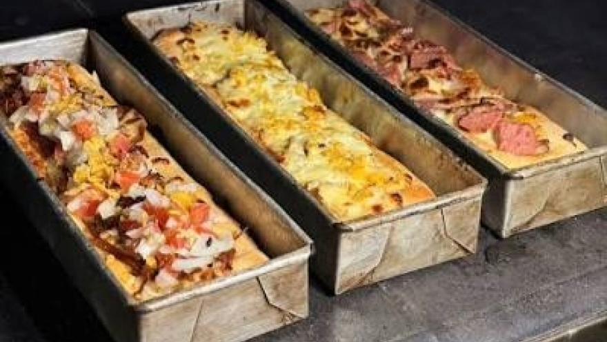 Pizzas de masa madre con diferentes ingredientes y coberturas, listas para hornear.