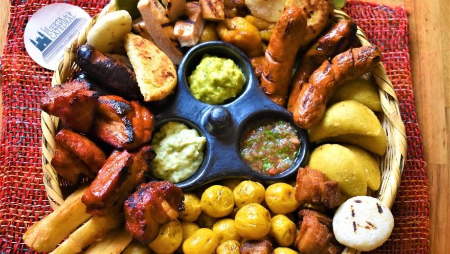 Colombian picada with meats, chorizos, arepas, potatoes, plantain, and sauces.
