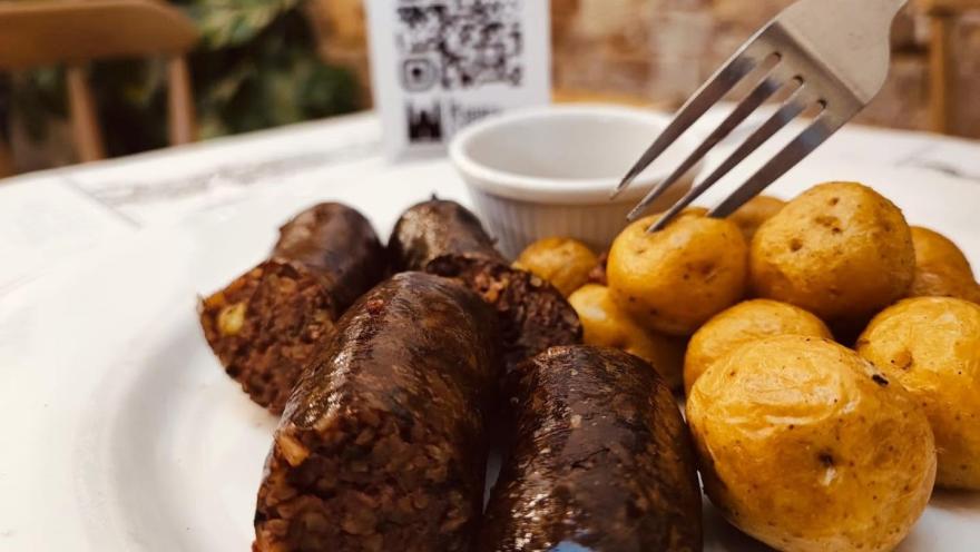 Colombian blood sausages accompanied by yellow potatoes served on a plate.  
