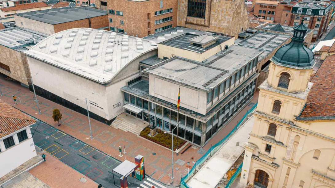 Luis Ángel Arango Library, wide shot from above with a drone, surrounded by buildings, the tower of La Candelaria Church, and empty streets.