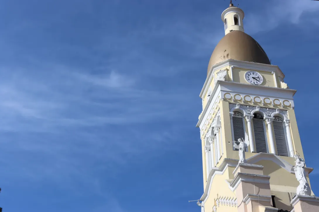 Iglesia Parroquial Inmaculada concepción - Cajicá su torre del reloj blanca con cielo azul.