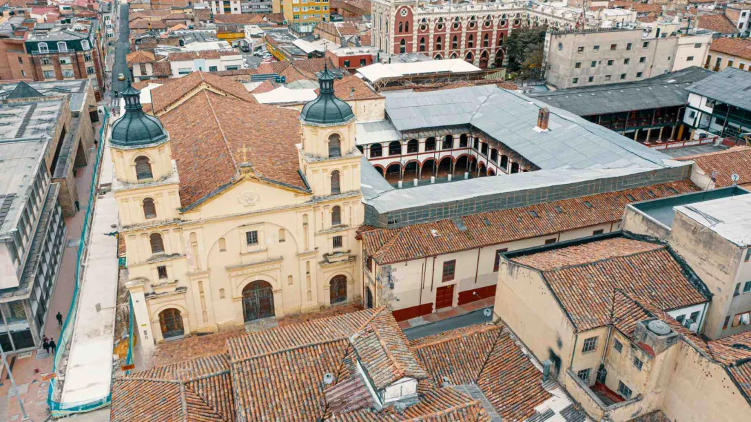  Iglesia de la Candelaria su fachada colonial , torres, techo y convento de la orden de los Agustinos Recoletos vista desde arriba con techos en teja de arro de otras edificacionjes alrededor. Imagen tomada con drone.