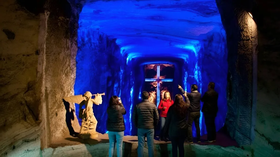 Catedral de Sal de Zipaquirá y turistas tomando fotos en el interior de la cueva del ángel y el fondo azul.