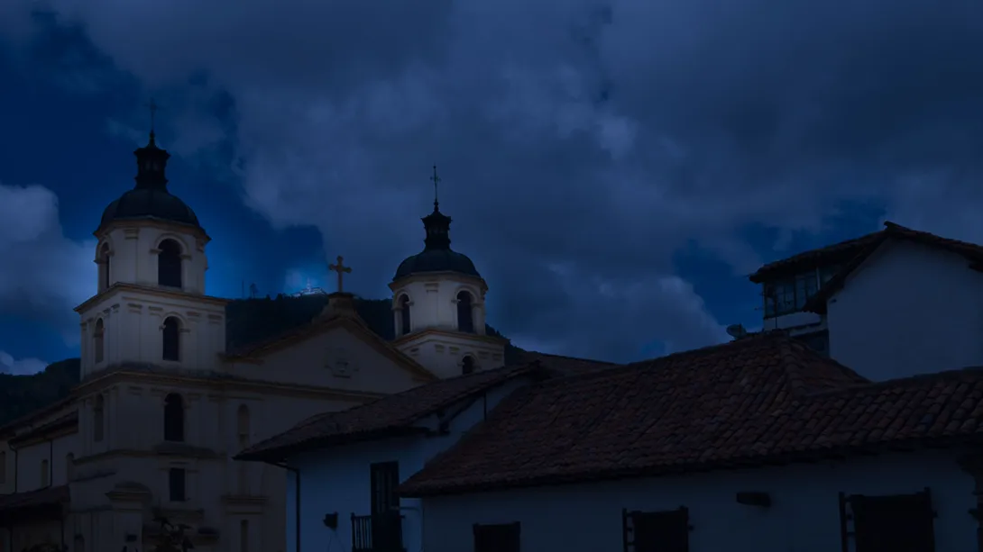 Techo de la iglesia de La Candelaria en tono azul como de anochecer. Se observa el techo en teja de barro de una casa vecina.
