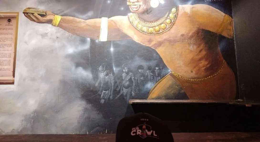 Un mural con unos indigenas jugando tejo. 