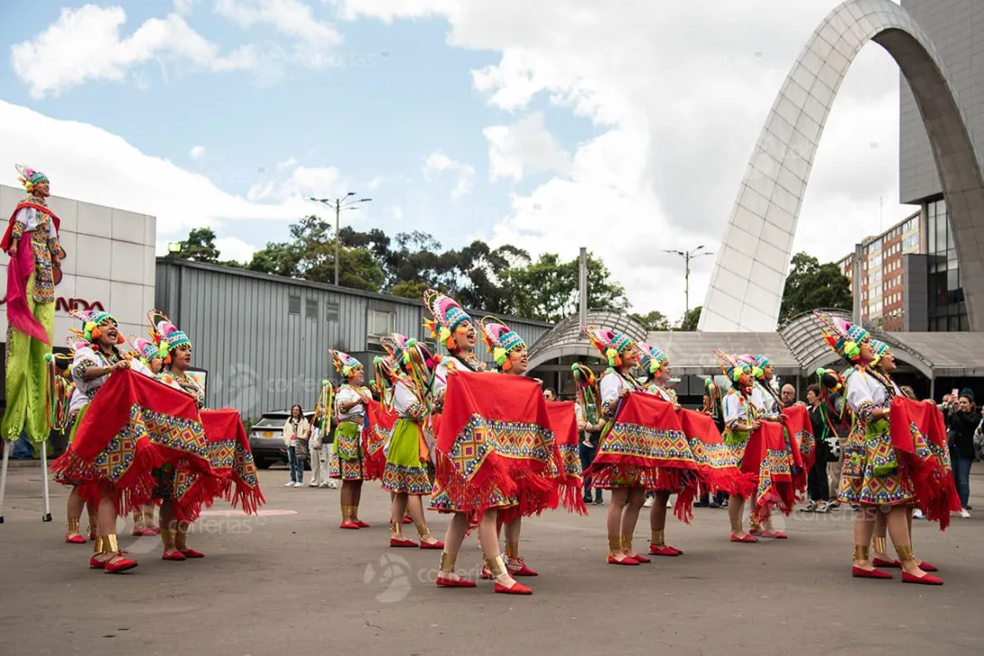 Grupo de mujeres bailarinas con ropas de alguna cultura indígena colombiana.  llevan faldas coloridas y sombreror de colores en fique.