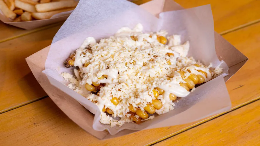  Elotes dulces cubiertos de mayonesa y queso fresco rallado, un delicioso antojo callejero.
