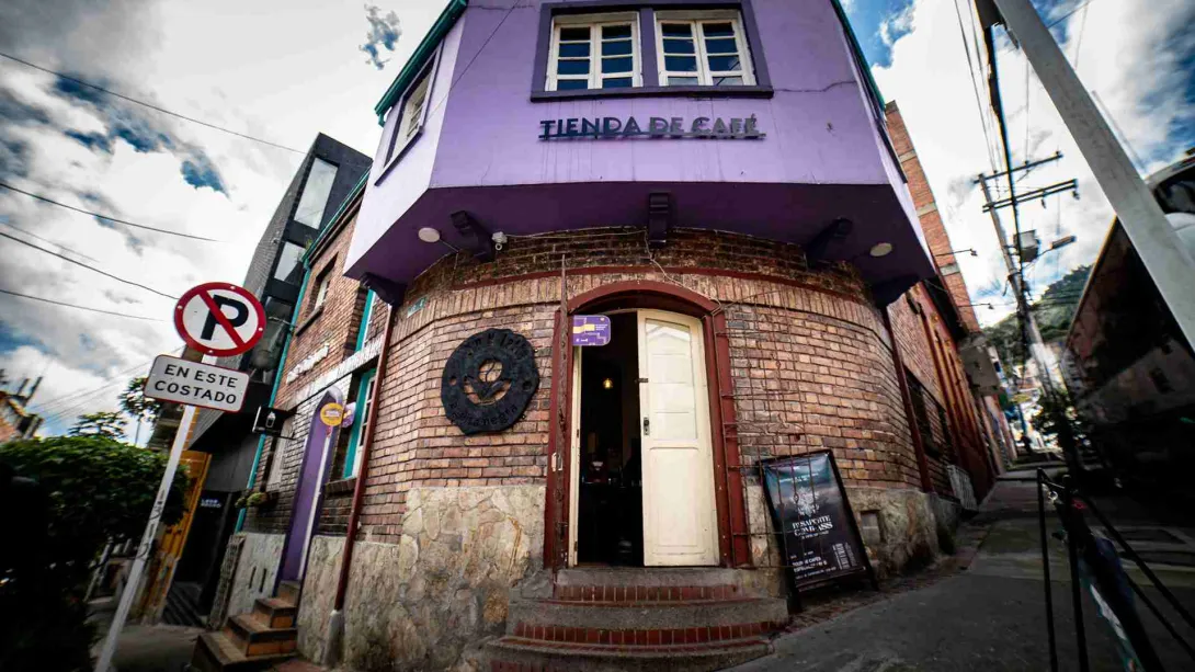 Fachada de edificación antigua de ladrillo y donde hay un aviso con una leyenda que dice: "Tienda de café".