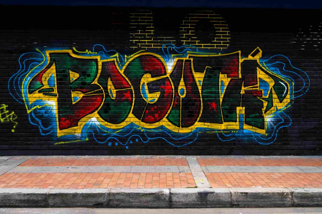Pared de ladrillo negra pintada de colores rojo, azul y amarillo con la palabra "Bogotá"