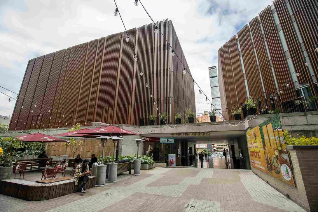Gran estructura entre madera y concreto con una puerta principal en la que destaca un aviso en bronce con una leyenda que dice: “Cinemateca”.