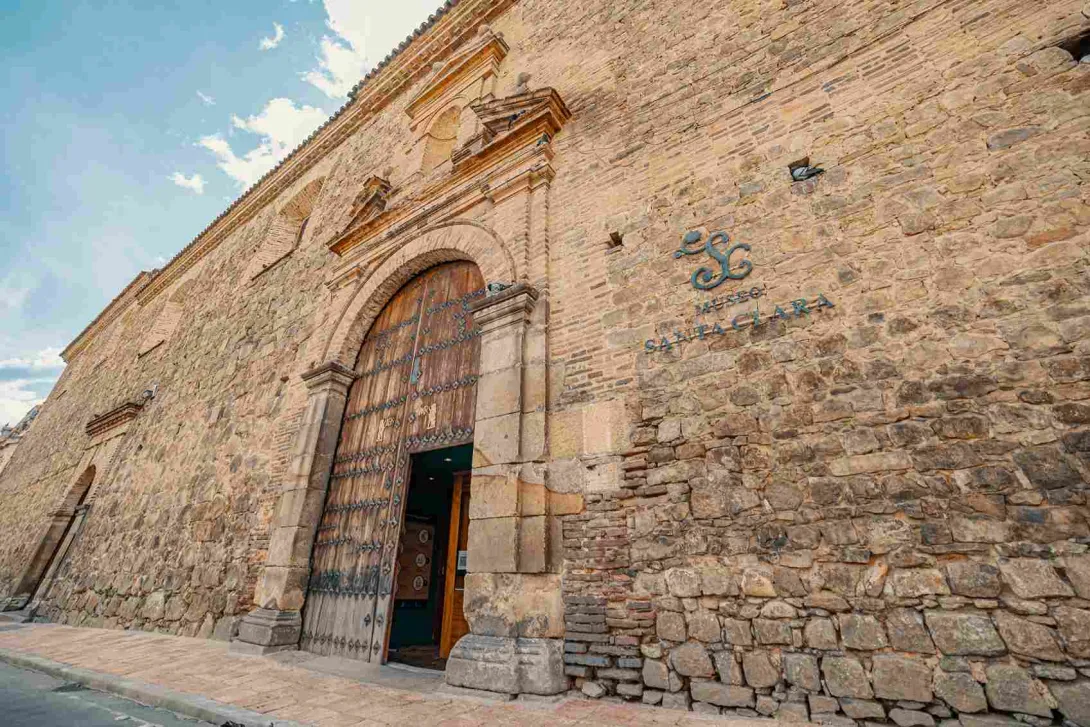 Fachada de edificio en placa de piedra con una leyenda que dice: "Museo Santa Clara".