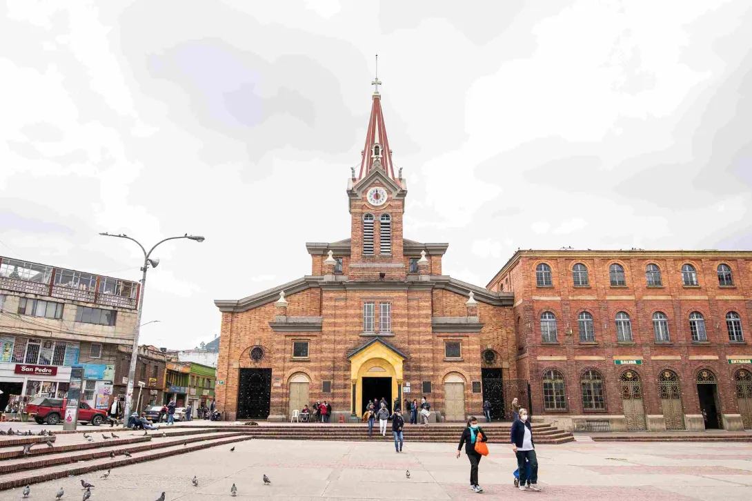 General view of the brick facade of the Church of the Divine Child. Its central tower with clock and bell tower is a prominent feature.